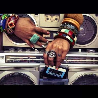 Hands putting a cassette tape into a boombox.